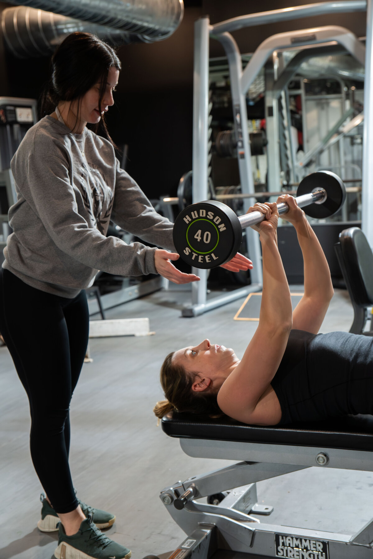 PrideFit coach guiding a member through a row